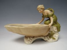 A ROYAL DUX FIGURE MODELLED AS A LADY HOLDING A SHELL, marks to base 1747 with pink triangle, W 22