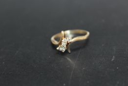 A FIVE STONE DIAMOND RING SET IN UNMARKED YELLOW METAL, approximate weight 3.1 g, ring size R