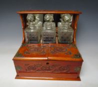 A EARLY 20TH CENTURY OAK CARVED THREE DECANTER TANTALUS, the tantalus with twin opening