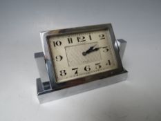 A FORTNUM & MASON ART DECO CHROMED TABLE CLOCK, the rectangular clock face swivelling on two