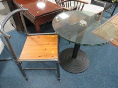 A MODERN GLASS TOP TABLE WITH AN INDUSTRIAL STYLE CHAIR