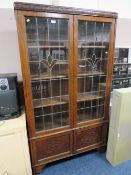 A VINTAGE OAK GLAZED TWO DOOR LEADED BOOKCASE H-183 W-102 CM