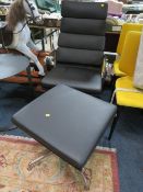 A MODERN BLACK SWIVEL ARMCHAIR WITH MATCHING FOOTSTOOL (2)