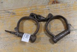 AN ANTIQUE SET OF HANDCUFFS WITH KEY