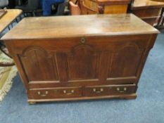 AN OAK MULE CHEST, the hinged lid above a fielded triple panel front with two drawers below,