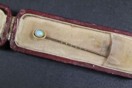 AN ANTIQUE GOLD STICK PIN SET WITH AN OPAL MARKED 15ct