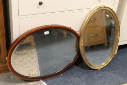 AN ANTIQUE OVAL MIRROR TOGETHER WITH A GILT OVAL MIRROR (2)