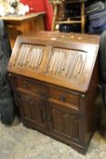 A REPRODUCTION OAK LINENFOLD BUREAU