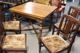 A VINTAGE OAK DRAWLEAF DINING TABLE WITH A SET OF FOUR SIMILAR OAK DINING CHAIRS