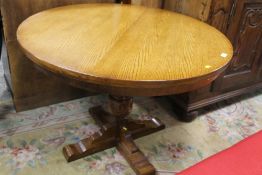 A REPRODUCTION OAK PEDESTAL DINING TABLE