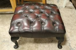 A REPRODUCTION OXBLOOD LEATHER FOOT STOOL