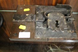 A VINTAGE METAL LOCK ATTACHED TO A WOODEN PANEL