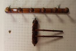 A VINTAGE WOODEN COAT RACK TOGETHER WITH A WALL MOUNTED DOUBLE RAIL