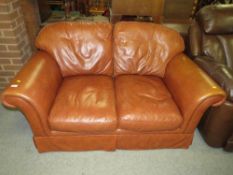 A SMALL BROWN LEATHER TWO SEATER SETTEE