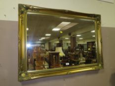 A LARGE MODERN GILT WALL MIRROR 75 X 106 CM