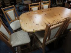 A HONEY PINE DINING TABLE AND SIX CHAIRS - ONE SPARE LEAF A/F