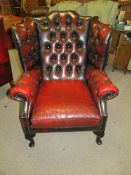 AN OX-BLOOD RED CLASSICAL WINGBACK ARMCHAIR