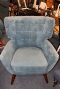 A MODERN UPHOLSTERED TEAL ARMCHAIR