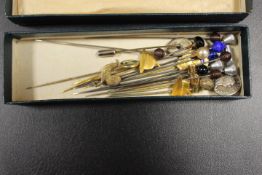 A SMALL BOX CONTAINING VARIOUS HAT PINS AND TIE PINS