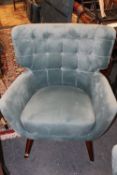 A MODERN UPHOLSTERED TEAL ARMCHAIR