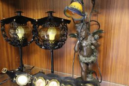 A SPELTER CHERUB TABLE LAMP, A PAIR OF MATCHING BLACK METAL TABLE LAMPS AND THREE HORSE BRASS