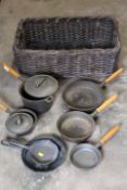 A BASKET OF CAST VINTAGE COOKING PANS