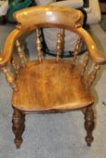 AN ANTIQUE SMOKERS BOW ARMCHAIR