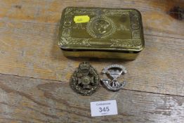 A WW1 PRINCESS MARY TIN CONTAINING TWO MILITARY BADGES