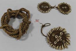 A BOX CONTAINING FOUR VINTAGE PAPUA NEW GUINEA BODY ORNAMENTS, one decorated with cowrie shells