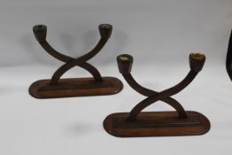A PAIR OF EARLY 20TH CENTURY MAHOGANY SECESSIONIST STYLE TWIN BRANCH CANDLESTICKS, raised on oval