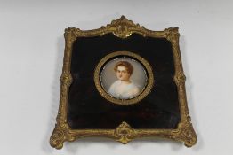A 19TH CENTURY CIRCULAR PORTRAIT STUDY OF A YOUNG WOMAN ON CERAMIC PANEL, unsigned, framed in