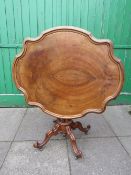 A 19TH CENTURY WALNUT SHAPED TILT-TOP CENTRE TABLE, the shaped top with stepped moulded edge,