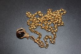 A HALLMARKED 9 CARAT GOLD CLAW HOLDING A TIGERS EYE BALL, on a link stamped 18 on an unmarked yellow