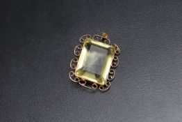 A LARGE GREEN / YELLOW RECTANGULAR PENDANT, possibly tourmaline? set in unmarked yellow metal,