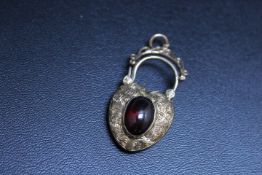 AN ANTIQUE MOURNING HEART SHAPED PADLOCK, set with a red cabochon stone and woven hair to the