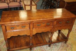 A 20TH CENTURY OAK THREE DRAWER DRESSER, raised on turned supports, with undertier, H 89 cm, W 166