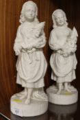 A PAIR OF VINTAGE PARIAN WARE STYLE FIGURINES OF YOUNG GIRLS HOLDING MR PUNCH PUPPETS