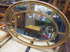 AN ANTIQUE OVAL GILT SECTIONAL WALL MIRROR - W 96 cm