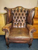 A VINTAGE BROWN LEATHER WINGBACK ARMCHAIR