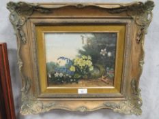 A FRAMED AND GLAZED OIL ON BOARD STILL LIFE STUDY OF A BIRDS NEST AND FLOWERS