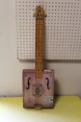 A CHILDS SIZE THREE STRINGS CIGAR BOX GUITAR