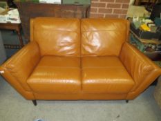 A MODERN TAN LEATHER TWO SEATER SETTEE - MINUS BACK FOOT