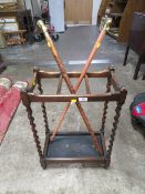 A 20TH CENTURY OAK BARLEYTWIST STICK STAND WITH TWO STICKS
