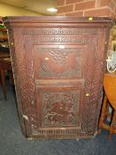 AN ANTIQUE CARVED OAK CORNER CUPBOARD