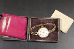 A HALLMARKED 9CT GOLD MANUAL WIND FOB WATCH CONVERTED TO A WRIST WATCH WITH ORNATE ENAMEL DIAL