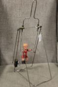 A VINTAGE CLOCKWORK 'CHILD ON A SWING', with metal frame, overall H 44 cm