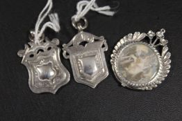 TWO HALLMARKED SILVER WATCH FOBS TOGETHER WITH AN UNMARKED LOCKET STYLE EXAMPLE (3)
