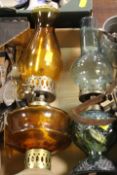 A TRAY OF ASSORTED SUNDRIES TO INCLUDE OIL LAMPS , FLATWARE COINS ETC