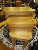 A MODERN OAK NEST OF TABLES - LARGEST W 69 cm