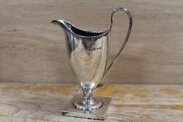 AN ANTIQUE SILVER CREAM JUG